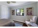 Cozy bedroom showcasing a comfortable armchair and window view of the outdoors at 7128 Teal Creek Gln, Lakewood Ranch, FL 34202