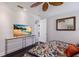 A light and bright bedroom with hardwood flooring has a television and en-suite bathroom at 7218 Teal Creek Gln, Lakewood Ranch, FL 34202