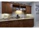 Inviting coffee bar with custom cabinetry, granite countertops, and ample display shelving for a warm and personalized touch at 7218 Teal Creek Gln, Lakewood Ranch, FL 34202