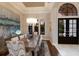 Elegant dining room featuring a tray ceiling, modern chandelier, and a view through arched windows, creating a sophisticated ambiance at 7218 Teal Creek Gln, Lakewood Ranch, FL 34202