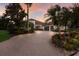 Beautiful home with a circular driveway, lush landscaping, and a three-car garage, exuding curb appeal and luxury at 7218 Teal Creek Gln, Lakewood Ranch, FL 34202