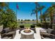 Backyard view of a fire pit with seating area overlooking a lake and golf course at 7218 Teal Creek Gln, Lakewood Ranch, FL 34202