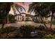 Elegant home with lush landscaping, a circular driveway, and a grand entrance, creating a welcoming and luxurious atmosphere at 7218 Teal Creek Gln, Lakewood Ranch, FL 34202