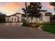 Well-maintained home featuring a circular driveway, mature landscaping, and a grand entrance, all bathed in the warm sunset light at 7218 Teal Creek Gln, Lakewood Ranch, FL 34202