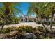 Stunning front exterior of a single-story home featuring a brick driveway and lush tropical landscaping at 7218 Teal Creek Gln, Lakewood Ranch, FL 34202