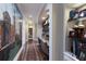 Hallway with an art wall leading to a built-in desk area and shelving filled with books and personal photos at 7218 Teal Creek Gln, Lakewood Ranch, FL 34202