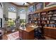 Spacious office boasts custom built-ins, a large desk, and natural light with views of manicured lawn at 7218 Teal Creek Gln, Lakewood Ranch, FL 34202