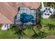 Aerial view of a screened-in pool area with a stone patio, surrounded by lush landscaping and a separate seating area at 7128 Teal Creek Gln, Lakewood Ranch, FL 34202