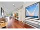 Hallway with hardwood floors, white walls, art and a bench at 7231 Brambury Ct, Sarasota, FL 34238