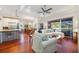 Living room with hardwood floors, white sofa and open concept to dining and kitchen at 7231 Brambury Ct, Sarasota, FL 34238