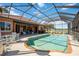 This home has a serene screened-in pool area with brick trim and outdoor seating at 7231 Brambury Ct, Sarasota, FL 34238