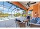 Screened in patio with a waterfront view, seating area, ceiling fan, and an inground swimming pool at 7231 Brambury Ct, Sarasota, FL 34238