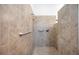 Close up of an accessible tiled shower space with a rainfall shower head, assist bars, and mosaic tile floor at 7231 Brambury Ct, Sarasota, FL 34238