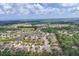 Aerial view of a housing community surrounded by lush trees with a lake at 7418 61St E St, Palmetto, FL 34221
