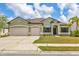 Well-manicured lawn, a driveway leading to a 3 car garage, and an inviting entrance at 7418 61St E St, Palmetto, FL 34221