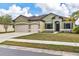 Well-manicured lawn, a driveway leading to a 3 car garage, and an inviting entrance at 7418 61St E St, Palmetto, FL 34221