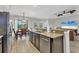 Open concept kitchen featuring granite counters, stainless appliances, and a breakfast bar, flowing into dining area at 7418 61St E St, Palmetto, FL 34221