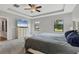 This main bedroom features a decorative tray ceiling, ceiling fan and large windows at 7418 61St E St, Palmetto, FL 34221