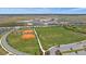 Aerial view of the community showcasing a school, baseball field, soccer field, and other recreational facilities at 7743 Nightfall Ter, Sarasota, FL 34241