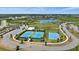 Community aerial view showcases tennis courts, basketball court, playgrounds, and a picturesque lake with surrounding homes at 7743 Nightfall Ter, Sarasota, FL 34241