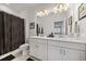 Bathroom features a double sink with white cabinets and a large mirror and shower with stylish dark curtain at 7743 Nightfall Ter, Sarasota, FL 34241