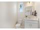 Half bathroom featuring a modern sink, toilet and a window letting in natural light at 7743 Nightfall Ter, Sarasota, FL 34241