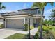 Charming two-story home with a gray exterior, a two-car garage, and a well-maintained, landscaped front yard at 7743 Nightfall Ter, Sarasota, FL 34241