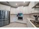 Modern kitchen with stainless steel appliances, white cabinets, and sleek countertops, offering style and functionality at 7743 Nightfall Ter, Sarasota, FL 34241