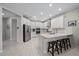 Bright, modern kitchen with white cabinets, stainless steel appliances, a breakfast bar, and wood-look tile flooring at 7743 Nightfall Ter, Sarasota, FL 34241