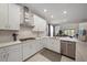 Bright kitchen featuring white cabinets, stainless steel appliances, and an open layout connecting to the living area at 7743 Nightfall Ter, Sarasota, FL 34241