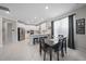 Open-concept kitchen with white cabinets, stainless steel appliances, a dining area and view into the living room at 7743 Nightfall Ter, Sarasota, FL 34241