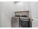 Modern laundry room features stainless steel washer and dryer, plus white cabinets above for ample storage at 7743 Nightfall Ter, Sarasota, FL 34241