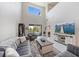 Open living room with soaring ceilings, a large window, modern decor, and a view of the screened pool area at 7743 Nightfall Ter, Sarasota, FL 34241