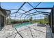 An in-ground pool and patio area enclosed by a black metal screened-in lanai at 7743 Nightfall Ter, Sarasota, FL 34241