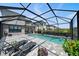 Relaxing screened-in pool area with lounge chairs, a basketball hoop, a waterfall feature, and a paver deck at 7743 Nightfall Ter, Sarasota, FL 34241