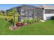 An enclosed patio with a pool and hot tub sits in a lush green backyard at 8195 Redonda Loop, Lakewood Ranch, FL 34202
