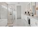 An elegant bathroom featuring a glass walk-in shower, a luxurious tub, and double vanities with custom lighting at 8195 Redonda Loop, Lakewood Ranch, FL 34202