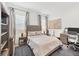 Well-lit bedroom features wood floors, a comfortable bed, a workspace with desk, and custom lighting at 8195 Redonda Loop, Lakewood Ranch, FL 34202