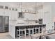 Modern kitchen features stainless steel appliances, white cabinets, a large island, and a stylish light fixture at 8195 Redonda Loop, Lakewood Ranch, FL 34202
