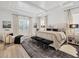 Bright bedroom featuring wood floors, decorative rug, tray ceiling, and inviting accent furniture at 8195 Redonda Loop, Lakewood Ranch, FL 34202