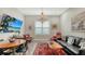 Inviting living room with a leather sofa, red armchairs, and a large window with plantation shutters at 8713 Mangilli Rd, Sarasota, FL 34238