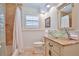 Bright bathroom featuring travertine tile, decorative glass sink, and white wainscoting at 10108 Kingfisher E Rd, Bradenton, FL 34209