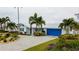 Charming single-story home with beautiful landscaping, blue shutters, and a blue garage door at 10108 Kingfisher E Rd, Bradenton, FL 34209