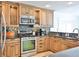 Kitchen boasts stainless steel appliances, granite countertops, custom cabinetry with glass accents, and tile floors at 10108 Kingfisher E Rd, Bradenton, FL 34209