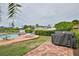 A covered grill sits near the pool and jacuzzi in this lush backyard setting at 10108 Kingfisher E Rd, Bradenton, FL 34209