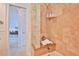 Shower featuring travertine tile, a built-in bench, and clear glass block detail at 10108 Kingfisher E Rd, Bradenton, FL 34209