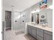 Modern bathroom with marble walk-in shower, double vanity, and decorative lighting at 10819 Wicker Park Pl, Palmetto, FL 34221