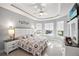 Bright bedroom with large windows, tray ceiling, a ceiling fan, and neutral decor at 10819 Wicker Park Pl, Palmetto, FL 34221