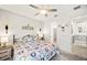 Bedroom with patterned bedding, a ceiling fan, and decor. An ensuite bathroom is connected at 10819 Wicker Park Pl, Palmetto, FL 34221