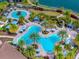 Aerial view showcasing a resort-style community pool featuring multiple swimming areas, lush landscaping, and comfortable seating at 10819 Wicker Park Pl, Palmetto, FL 34221